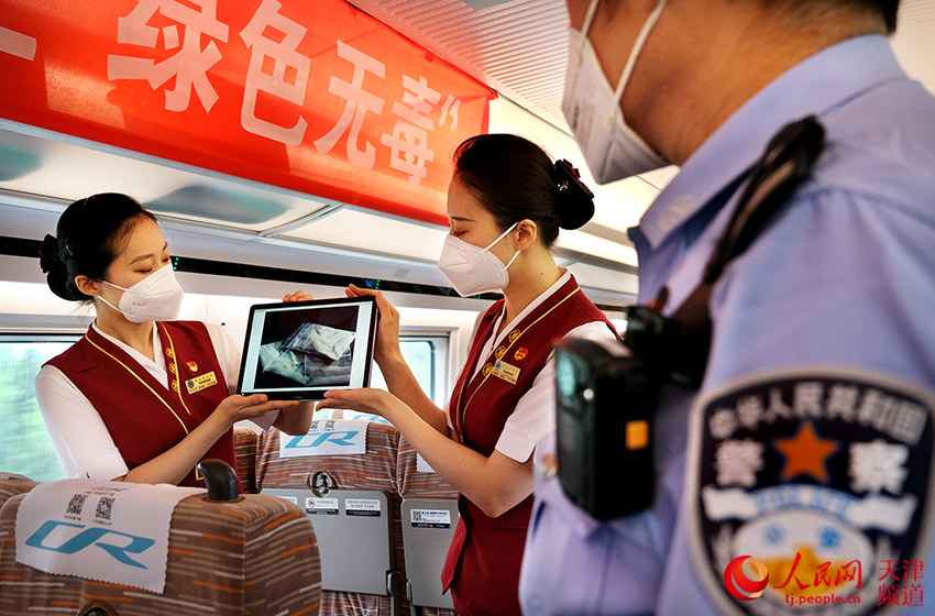 鐵路天津客運段乘務人員與乘警向旅客講解有關毒品的危害及相關常識。楊寶森/攝