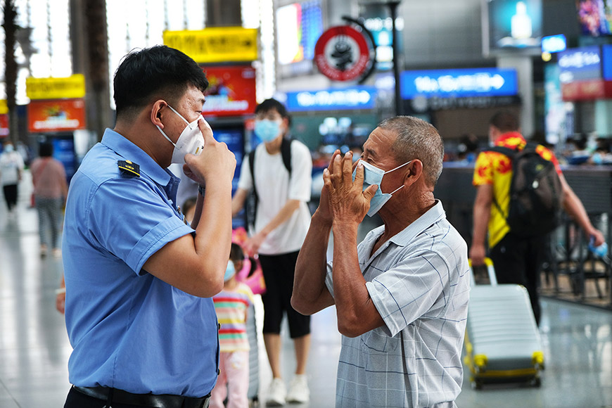 8月6日，铁路天津站工作人员在候车大厅指导旅客规范佩戴好口罩。杨宝森摄