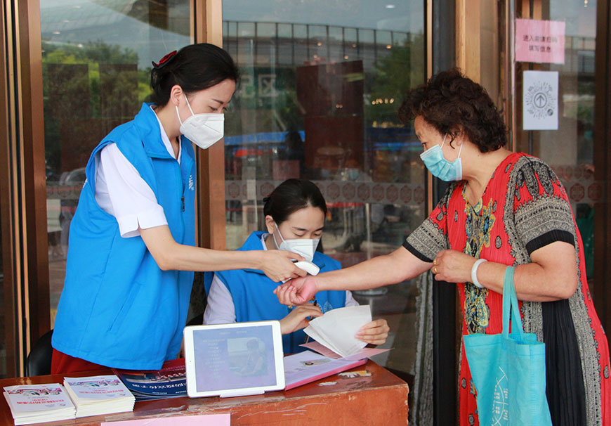 天津客運段志願者們在社區為接種群眾進行測溫登記。天津客運段供圖