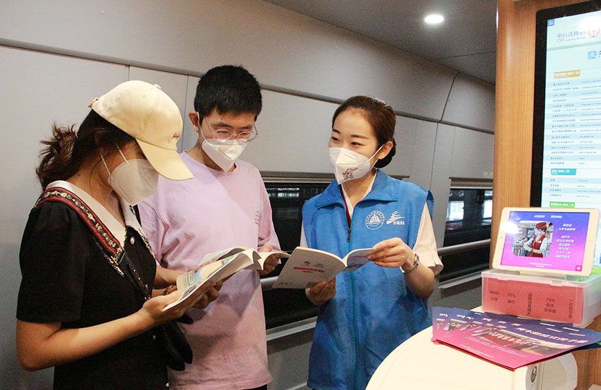 天津客運段G5次乘務組志願者在列車上向旅客介紹防疫小知識。天津客運段供圖