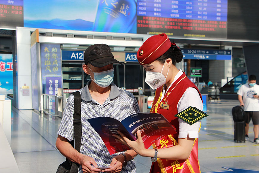 天津客運段津滬高鐵車隊G5次乘務組志願者在車站為旅客發放列車防疫宣傳冊。天津客運段供圖
