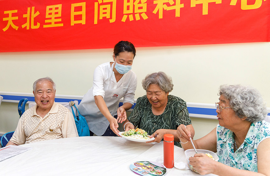 工作人员为老年人送上美味的午餐。王英浩摄