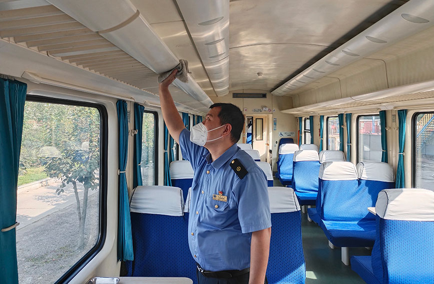 天津客運段Z206次列車乘務員為恢復車容車貌正在擦拭行李架。天津客運段供圖