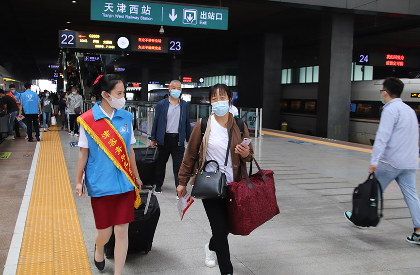 志願者協助旅客提拿行李。天津客運段供圖