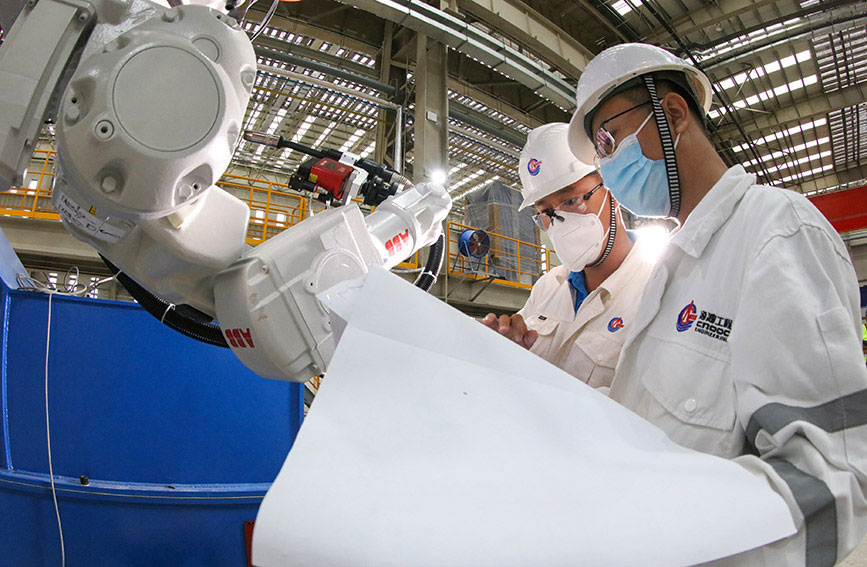 工作人員對平面分段生產線裝焊工場打磨機器人進行調試。天津港保稅區供圖