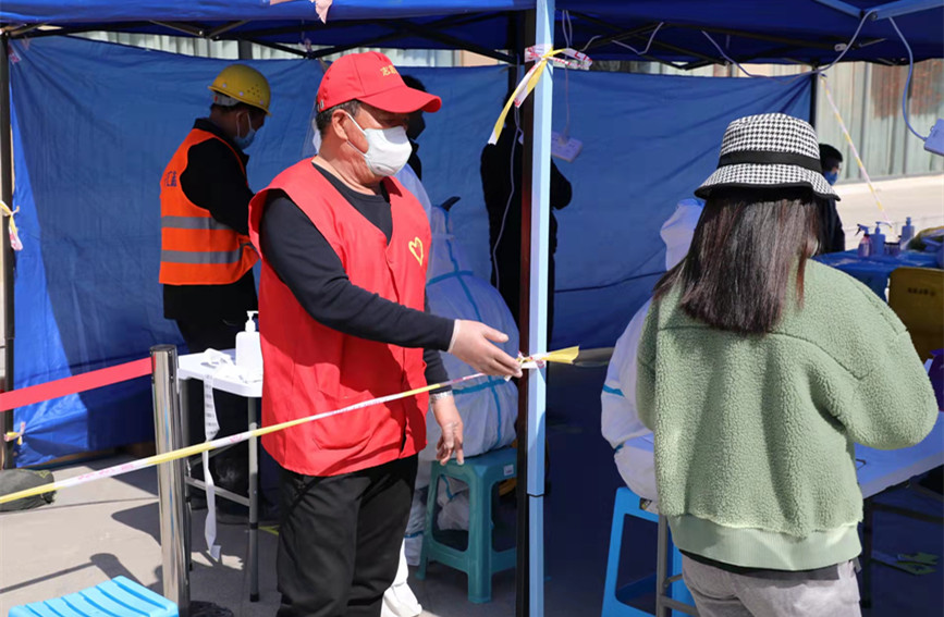 在西青區社區核酸檢測點，志願者在現場維持秩序。西青區委宣傳部供圖