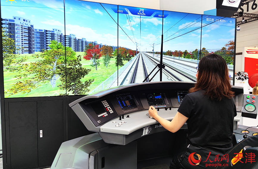 参会人员体验高铁模拟驾驶系统。人民网 孙一凡摄