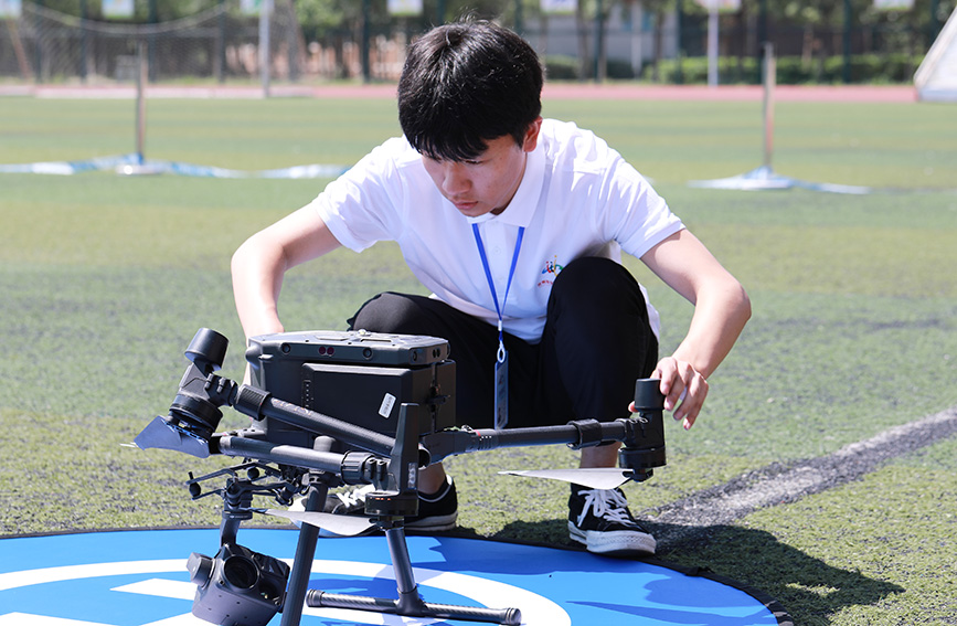 參加無人機維修與應用賽項的選手完成自動巡檢前無人機的飛行檢查。劉嘉鑫攝