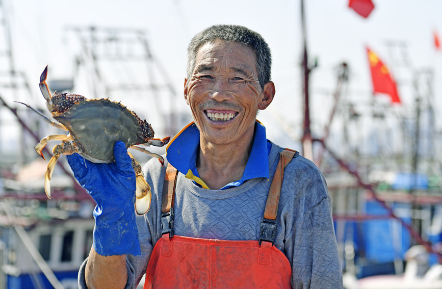 一位渔民手中拿着捕获的大螃蟹。贾磊摄