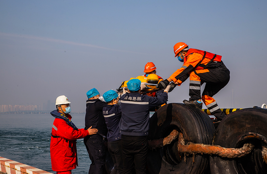 救援人員將落水人員轉移至碼頭。天津海事局供圖
