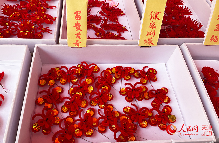 天津的红绒花头饰，寓意吉祥。人民网 唐心怡摄
