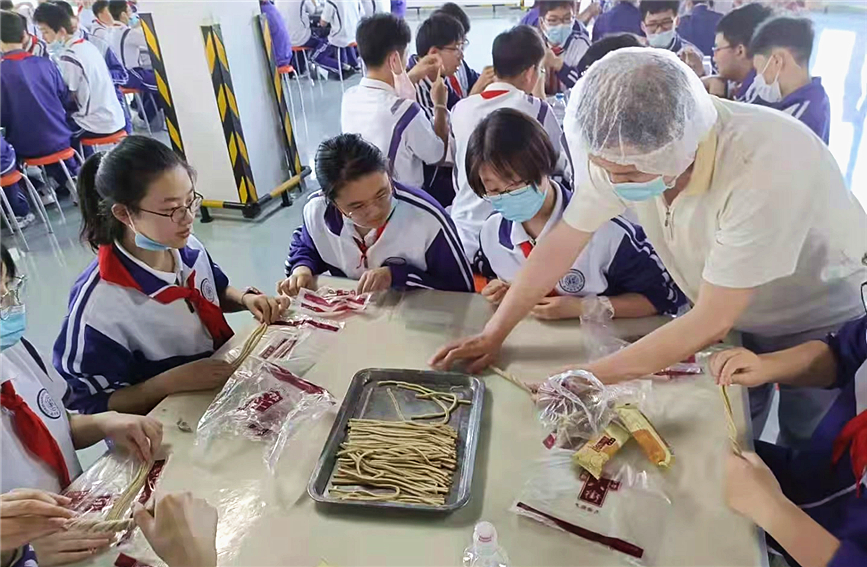孩子们在天津桂发祥十八街麻花工厂体验非物质文化遗产“撂麻花”。滨海新区区委宣传部供图