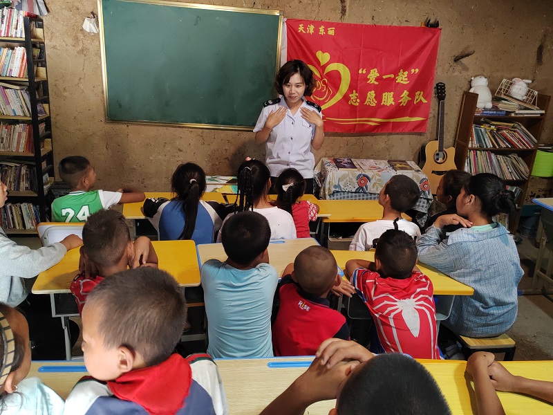 “爱一起”志愿服务队志愿者换上工作制服，为大山里的孩子们讲了一堂生动的税法课。天津市东丽区税务局供图