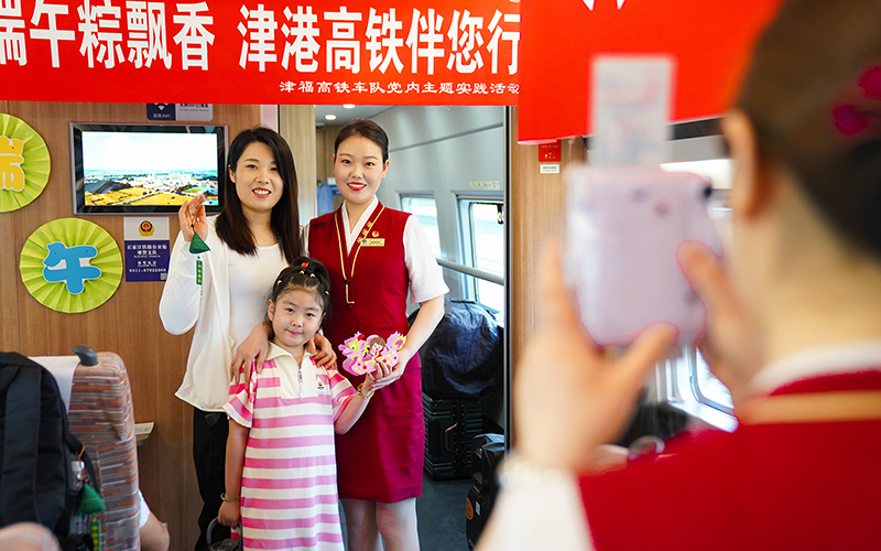 6月22日，G305次列车乘务人员为旅客合影留念，记录美好一刻。刘超摄