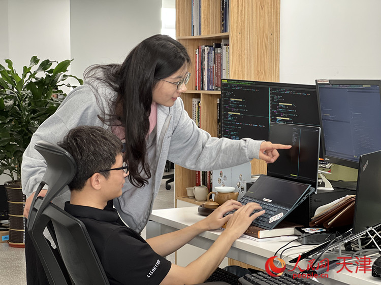 在麒麟軟件終端研發部，兩名研發人員正在就代碼問題進行交流。人民網記者 孫翼飛攝