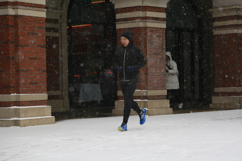 市民冒雪在民园广场跑步。人民网记者 崔新耀摄