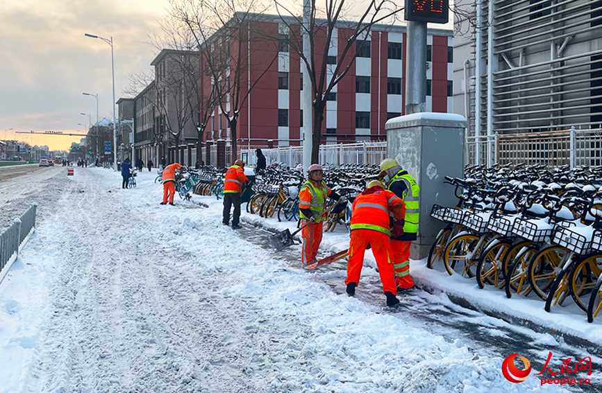 勤俭道地铁站附近，环卫工人奋力清扫积雪。人民网记者 唐心怡摄