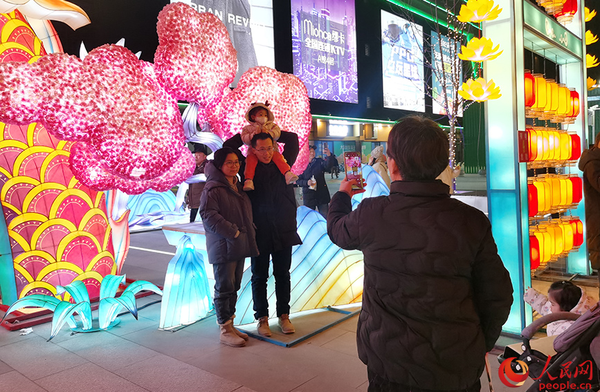 2023年12月31日，天津市民在西青大悅匯龍形燈飾前拍照留念。人民網記者 陶建攝