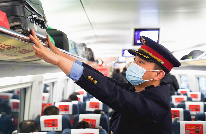 1月26日，春運首日，乘務員幫助旅客擺放行李。中國鐵路北京局供圖
