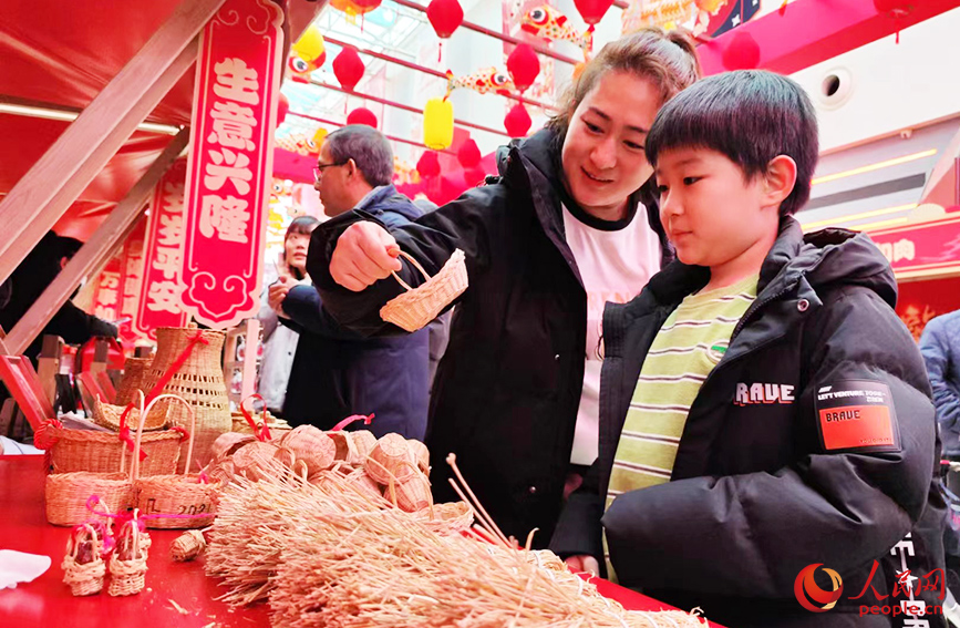 市民在“竹编草编技艺”摊位前驻足，沉浸式感受来源于生产生活实践的非遗传统技艺。人民网 郭维瑾摄