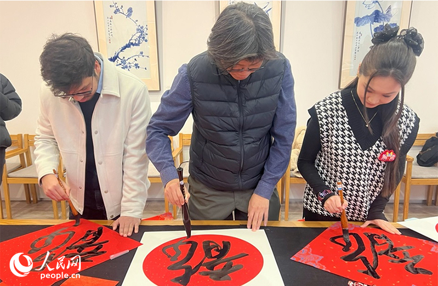 留學生向藝術家老師學習書寫“龍”字。實習生馬雪晴攝