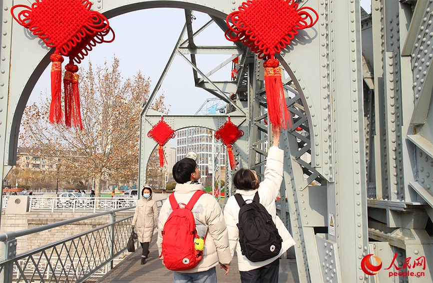 市民被天津解放桥上的中国结吸引，游玩之余驻足观赏。实习生马雪晴摄