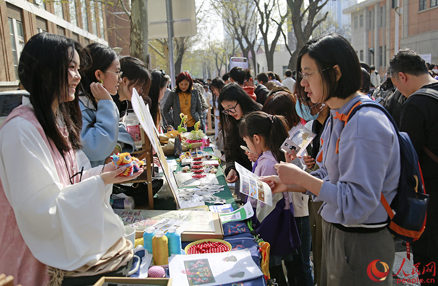 海棠樹下，天大學子向游客展示中國傳統手工制品。人民網記者 崔新耀攝