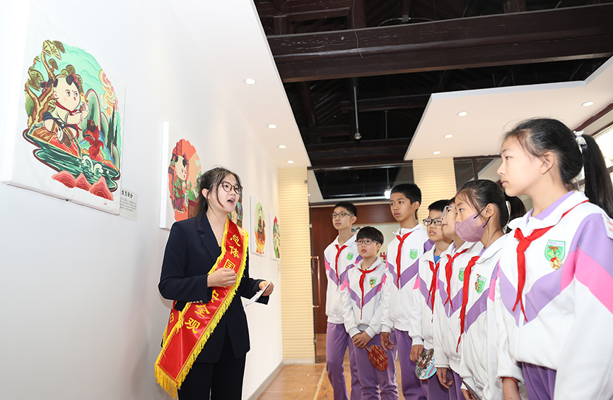 學生代表跟隨講解人員參觀藝術展。西青區委宣傳部供圖