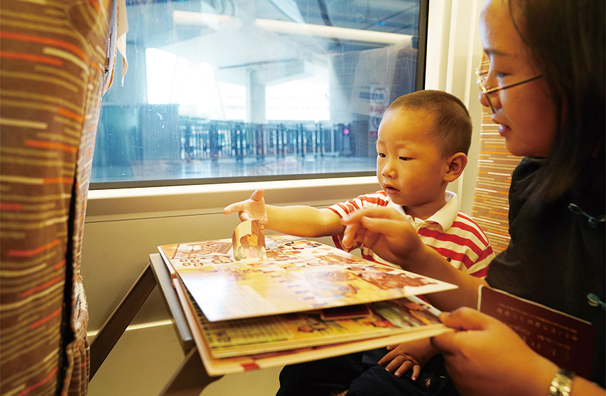 旅途中，儿童在玩津兴城际铁路工作人员提供的趣味玩具。中国铁路北京局供图