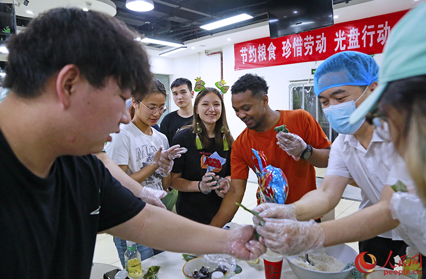 学生在厨师的讲解下包粽子。人民网记者 崔新耀摄