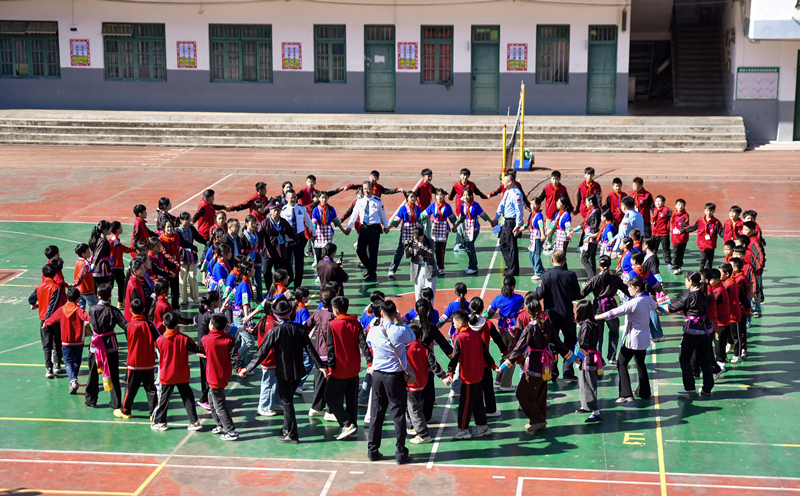 广西三江侗族自治县富禄苗族乡中心小学师生与天津边检总站民警代表手拉手舞蹈。天津边检总站供图