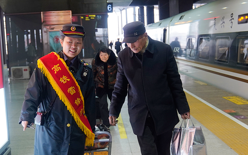 天津西站高铁“雷锋班”成员为旅客提供服务。张伯辰摄