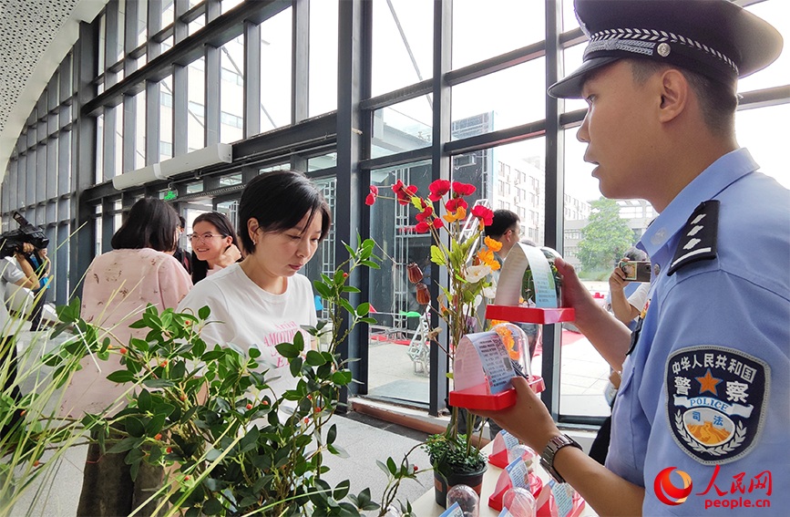 戒毒警察向往来师生介绍仿真毒品模型。人民网 郭维瑾摄