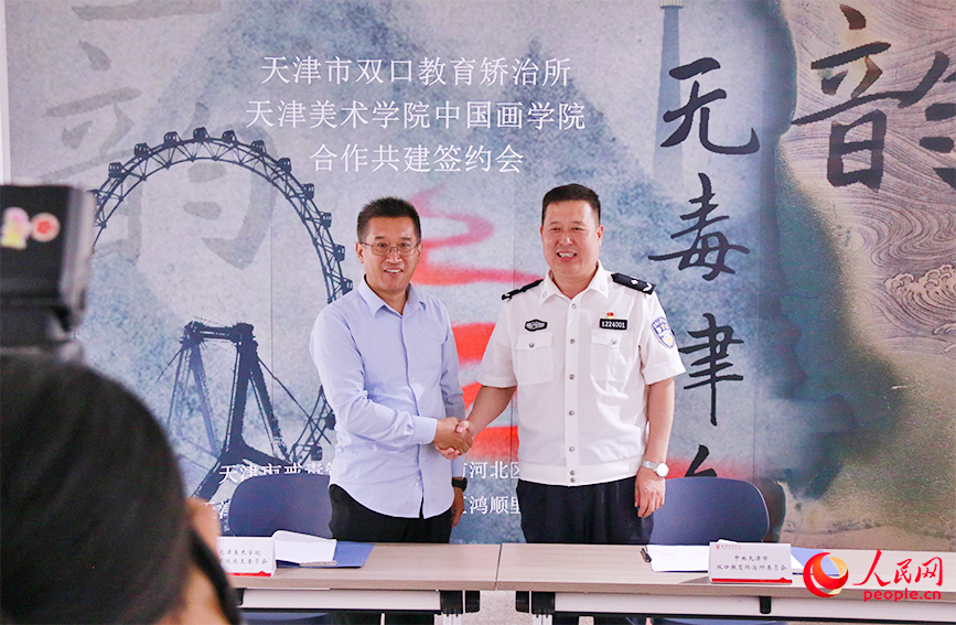 天津市双口强制隔离戒毒所党委书记与天津美术学院中国画学院党总支书记签署《党建共建合作协议》。人民网实习生 齐冠翔摄