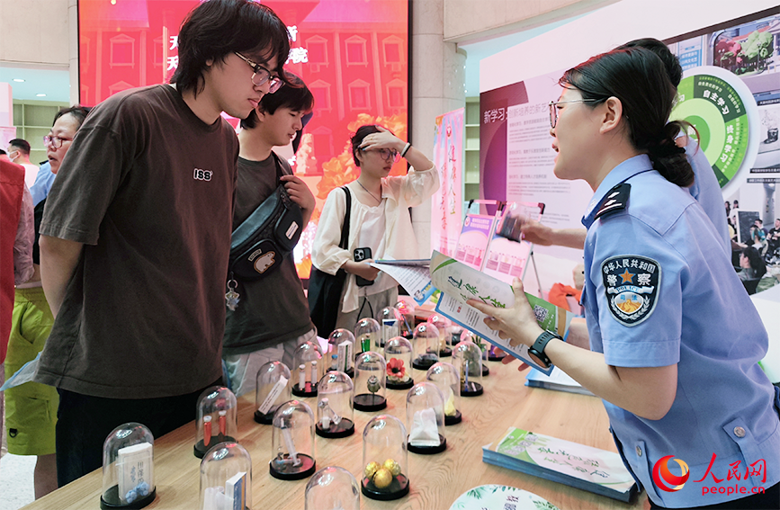 活動間隙，天津市雙口強制隔離戒毒所警察向過往同學們介紹仿真毒品模型。人民網 郭維瑾攝