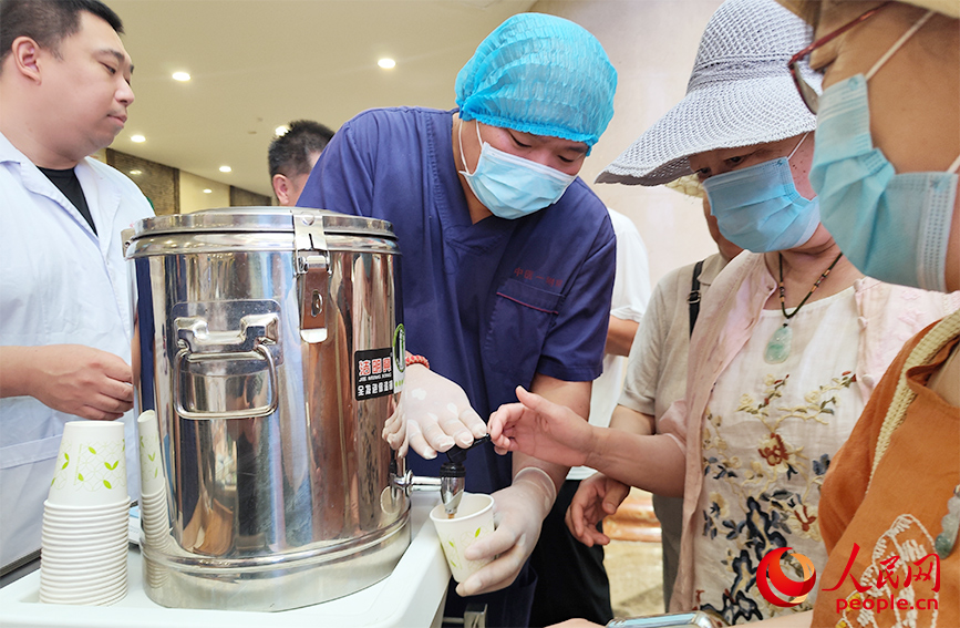 市民排隊領取中藥消暑飲品。人民網 郭維瑾攝