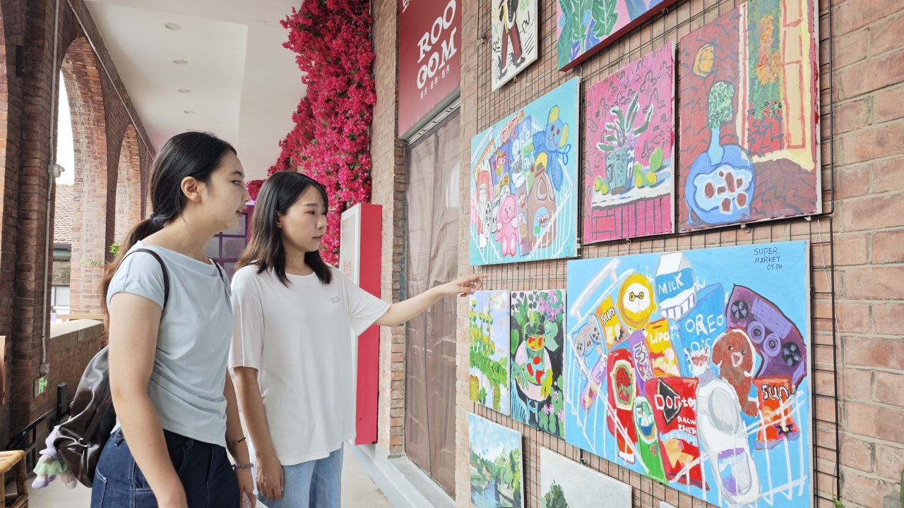 在原意大利兵營內的藝術商店門前，記者欣賞繪畫作品。