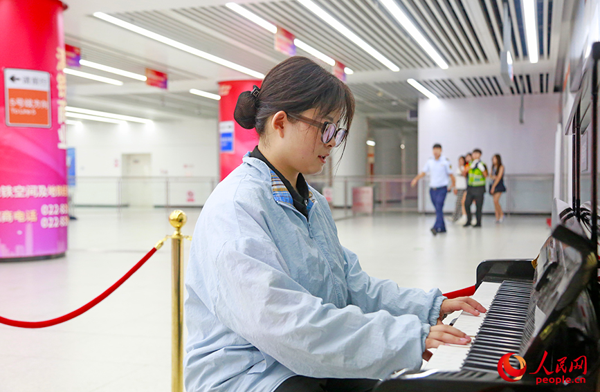乘客在直沽地鐵站彈奏共享鋼琴。人民網記者 崔新耀攝