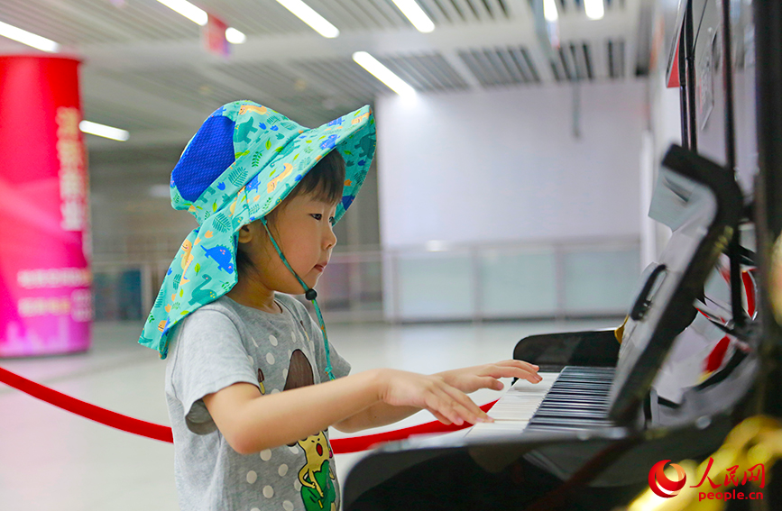 乘客在直沽地鐵站彈奏共享鋼琴。人民網記者 崔新耀攝
