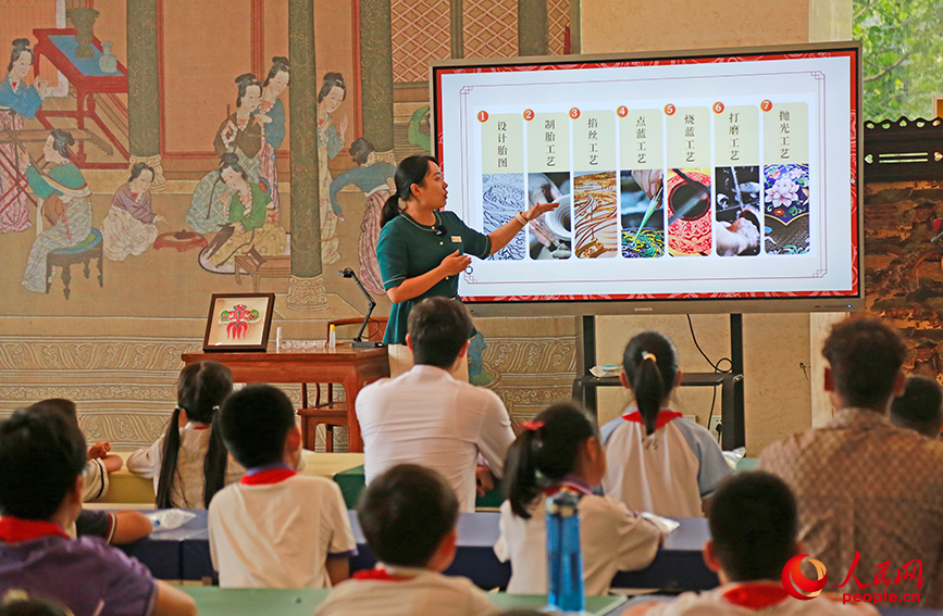 工作人员对非物质文化遗产代表性项目——掐丝珐琅粉彩画制作工艺进行讲解。人民网记者 崔新耀摄