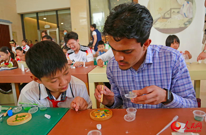 中外青少年共同繪制掐絲琺琅粉彩畫。人民網記者 崔新耀攝