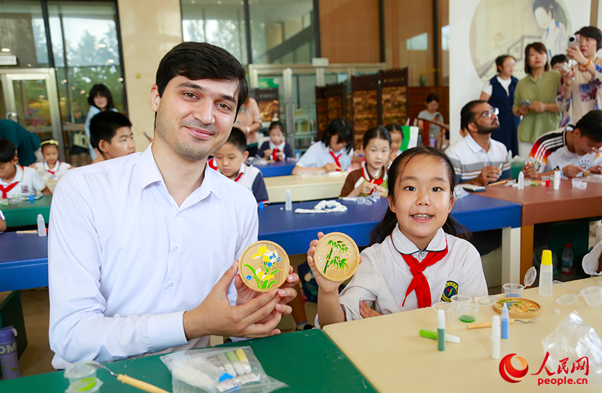 中外青少年展示繪制的掐絲琺琅粉彩畫。人民網記者 崔新耀攝