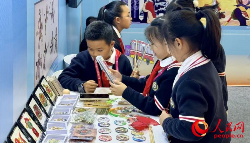 小朋友在观看皮影作品。人民网 记者杨睿摄