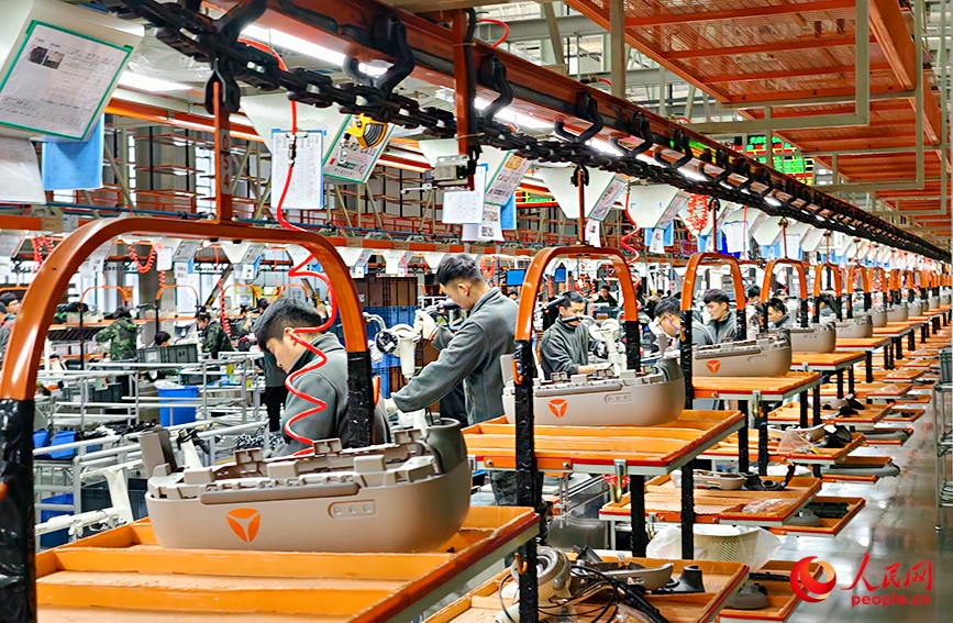 “站立”的电动自行车在总装线上有序移动。人民网记者 郭维瑾摄