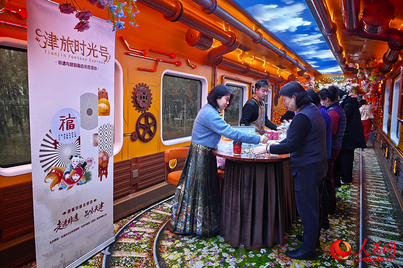 在传承人的指导下,乘客亲手制作属于自己的非遗作品。人民网记者 孙一凡摄