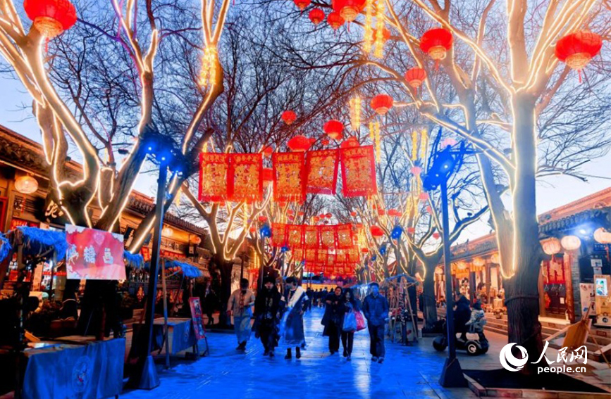 霓虹灯牌点亮古风门楼，新年仪式感悄然铺陈。人民网记者 许维娜摄