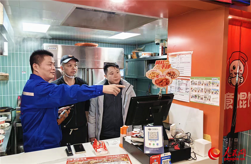 工作人員向餐館老板進行用氣安全知識講解。人民網記者 李丹攝