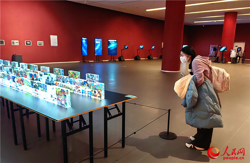 由多幅青少年画作组成的“水晶长城”艺术装置，在灯光下晶莹剔透，吸引观众近距离观看。人民网记者 李丹摄