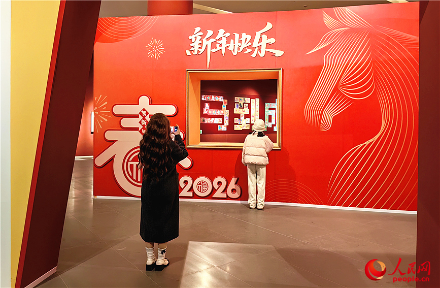 展厅入口处，红色布景墙格外醒目，成为市民游客打卡留影的热门点位。人民网记者 李丹摄 