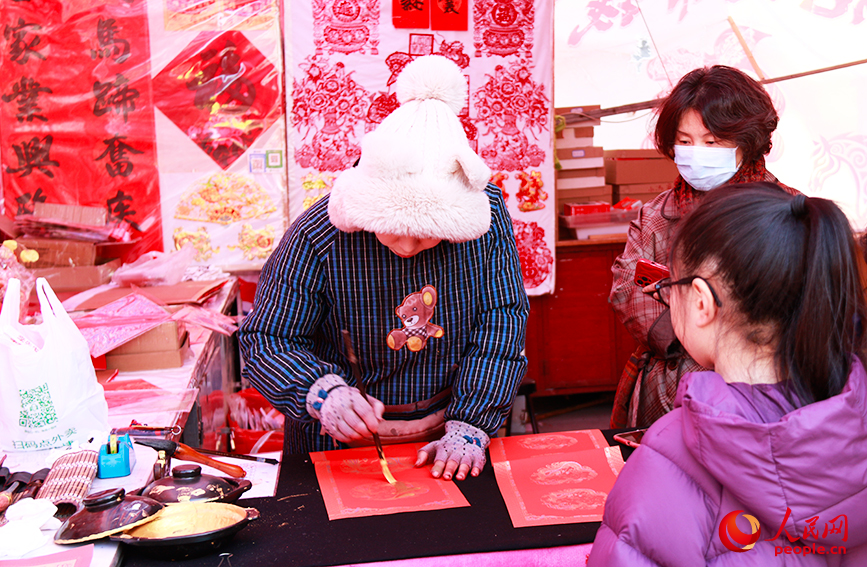 攤主為游客寫新春對聯。人民網記者 唐心怡攝